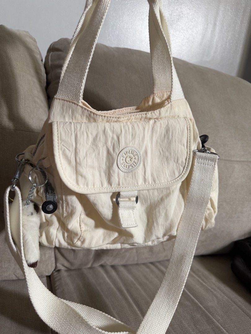Kipling White Nylon Shoulder Bag with Crossbody Strap (Category: Shoulder Bags) located in Makati City. Submitted by triftedandbranded (Listing ID 1470230543, Image 2). Description: - Authentic white Kipling shoulder bag made from durable, lightweight nylon - Versatile design featuring both top handles and an adjustable/removable crossbody strap - Excellent storage with a front flap pocket, side zip pockets, and a spacious main compartment - Incl