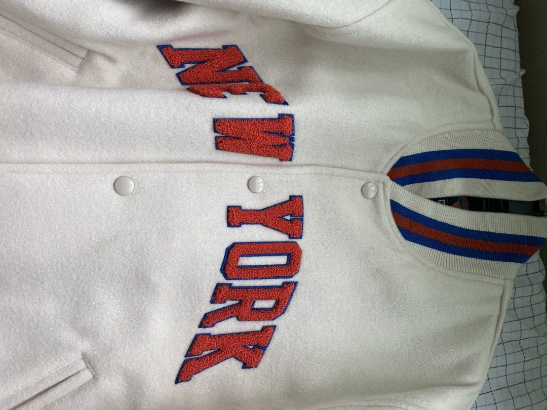 Kith x New York Knicks Golden Bear Varsity Jacket (Category: Coats, Jackets and Outerwear) located in Quezon City. Submitted by viber9163490242 (Listing ID 1470223690, Image 3). Description: - Brand: Kith x New York Knicks (in collaboration with Golden Bear) - Material: Premium off-white wool body with quilted black inner lining - Design: Bold orange and blue chenille 'New York' lettering across the front - Details: Embroidered Kith & Knicks bran