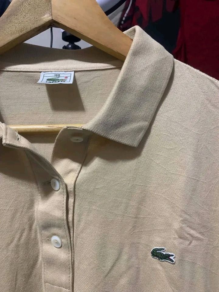 Lacoste (Category: Tshirts & Polo Shirts ) located in Caloocan City. Submitted by adonebarro03722 (Listing ID 1470168252, Image 2). Description: - Authentic beige Lacoste polo shirt - Classic cotton piqué fabric with great structure - Short sleeves with traditional button placket - Small embroidered green crocodile logo on the chest - Size: 100 (Korean care label on inside seam) - Clean and well-maintained condition - Ideal for casual or smart-ca