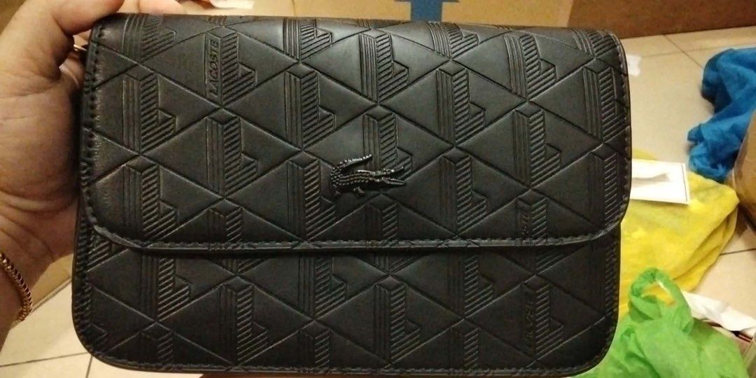 Lacoste Black Geometric Pattern Crossbody Bag (Category: Sling Bags) located in Cebu City. Submitted by catherinesep (Listing ID 1470246895, Image 1). Description: - Authentic Lacoste black crossbody bag - Stylish textured geometric pattern all over - Iconic metal crocodile logo on the front flap - Sleek dark hardware and clean stitching - Structured rectangular shape with a secure foldover flap closure - Roomy interior designed to fit your daily