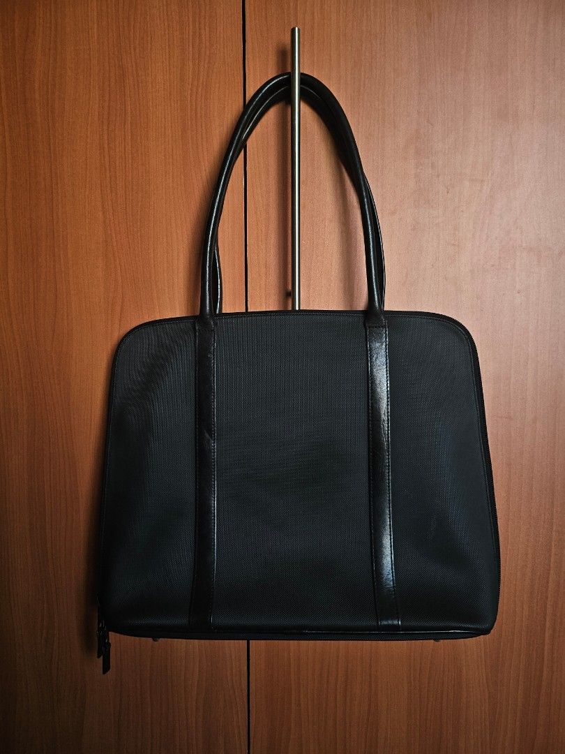 Lacoste Black Tote Bag Laptop Briefcase (Category: Tote Bags) located in Mandaluyong City. Submitted by ohwmaria (Listing ID 1470229675, Image 2). Description: -Laptop/Ipad/Tablet/Document bag - Color: Classic Black - Material: Textured nylon fabric with premium leather trim - Design: Structured rectangular shape with dual top handles - Logo: Distinctive triangular leather patch with embossed Lacoste crocodile - Closure: Secure top zip closure - 