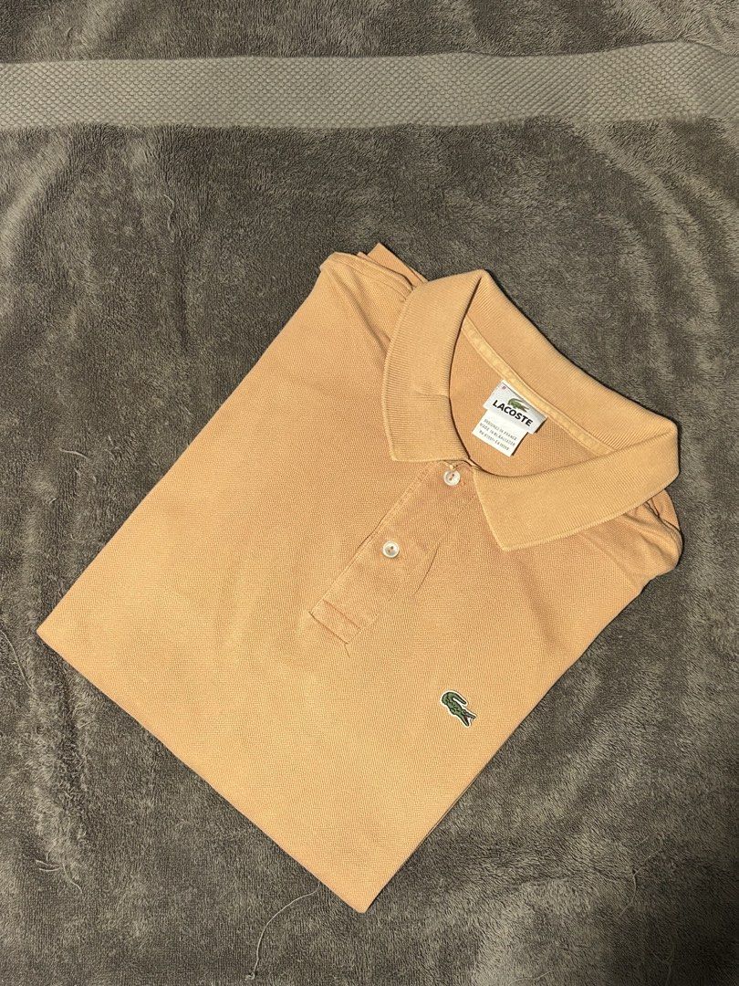 Lacoste Orange Polo Shirt Size 8 (Category: Tshirts & Polo Shirts ) located in San Simon. Submitted by ericdeinla69664 (Listing ID 1470189098, Image 1). Description: - Brand: Lacoste - Color: Vibrant Orange - Size: 8 - Material: 100% Cotton - Design: Classic two-button collar with embroidered green crocodile logo - Origin: Designed in France, Made in El Salvador - Style: Solid color casual wear - Authenticity tags attached (RN 87651, CA 16998).