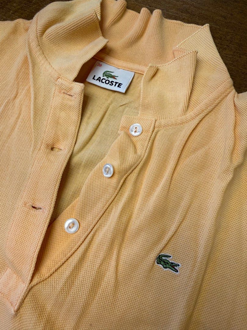 Lacoste Peach Polo Shirt Size 38 (Category: Shirts) located in Muntinlupa City. Submitted by el1b12345 (Listing ID 1470183768, Image 2). Description: - Brand: Lacoste - Color: Peach - Size: 38 (Standard fit) - L - 22" - W - 17" - Classic two-button placket with white buttons - Traditional ribbed collar and sleeve cuffs - Signature embroidered green crocodile logo on left chest - Clean inner brand tag - mop: Gcash - mod: Lalamove/J&T - Price Negot