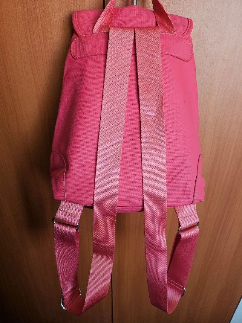 Lacoste Pink PVC Backpack (Category: Backpacks) located in Mandaluyong City. Submitted by ohwmaria (Listing ID 1470239978, Image 2). Description: -The bag may have some folds due to storage, but they should smooth out naturally with use -Needs cleaning, small pen mark as seen sa photo - Authentic bright pink Lacoste backpack made from durable woven nylon and pvc - Features a front flap with buckle closure and branded metal eyelets - Classic green