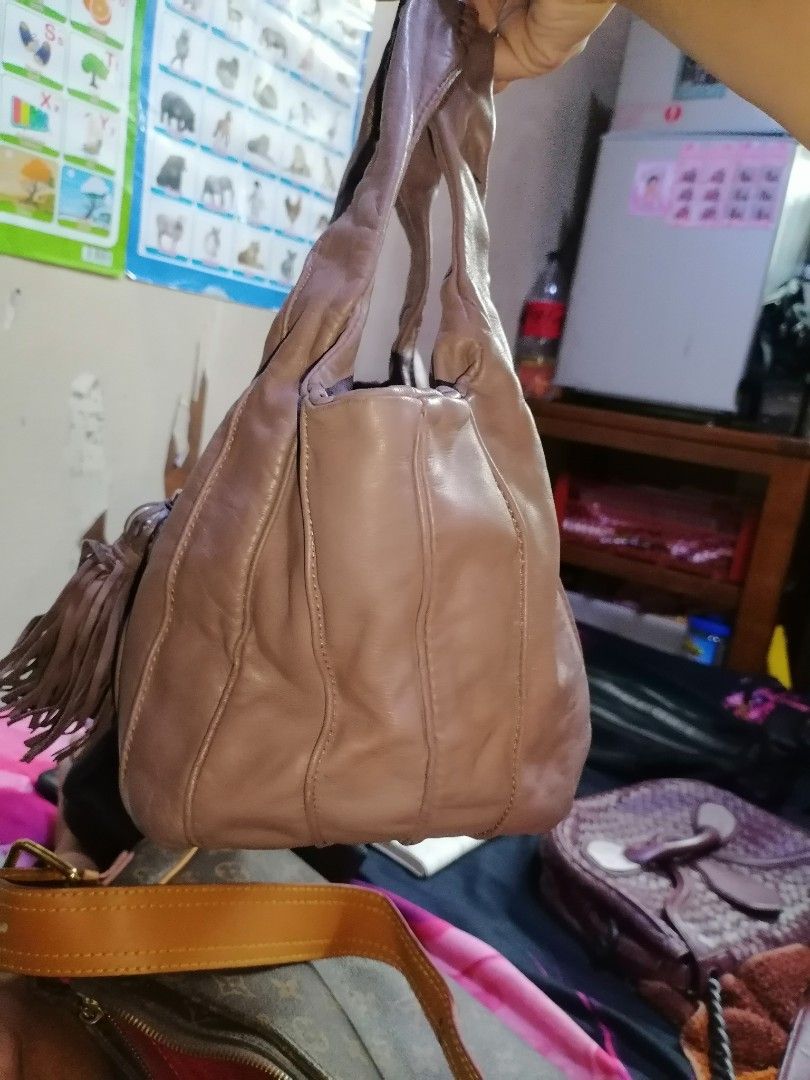 Lancel Leather Shoulder Bag with Tassel (Category: Shoulder Bags) located in Digos. Submitted by crodualady82694 (Listing ID 1470158656, Image 3). Description: - Brand: Lancel - Color: Dusty mauve / taupe - Material: Soft, slouchy genuine leather with vertical panel stitching - Accents: Large matching leather tassel and exterior embossed logo tab - Straps: Dual comfortable shoulder straps - Interior: Clean lining with a spacious everyday fit.