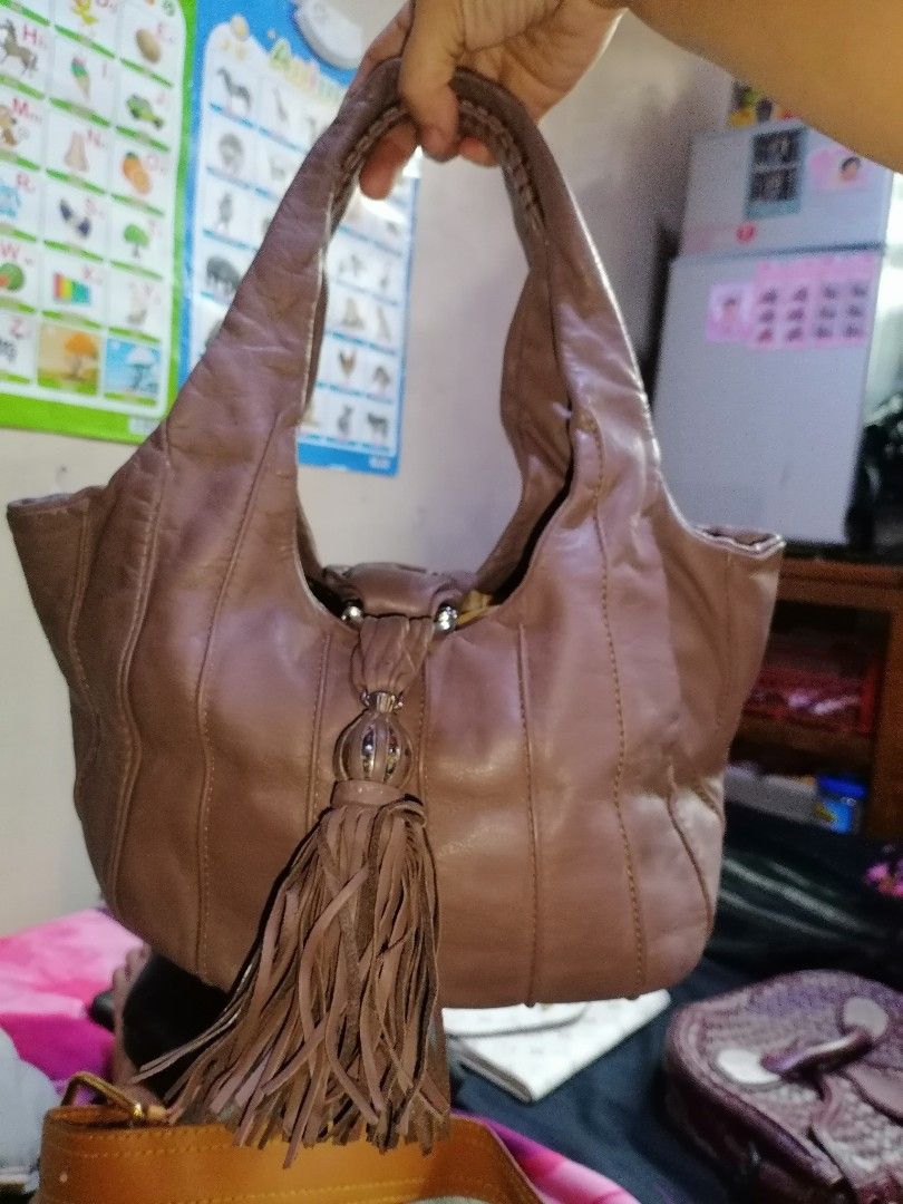 Lancel Leather Shoulder Bag with Tassel (Category: Shoulder Bags) located in Digos. Submitted by crodualady82694 (Listing ID 1470158656, Image 1). Description: - Brand: Lancel - Color: Dusty mauve / taupe - Material: Soft, slouchy genuine leather with vertical panel stitching - Accents: Large matching leather tassel and exterior embossed logo tab - Straps: Dual comfortable shoulder straps - Interior: Clean lining with a spacious everyday fit.