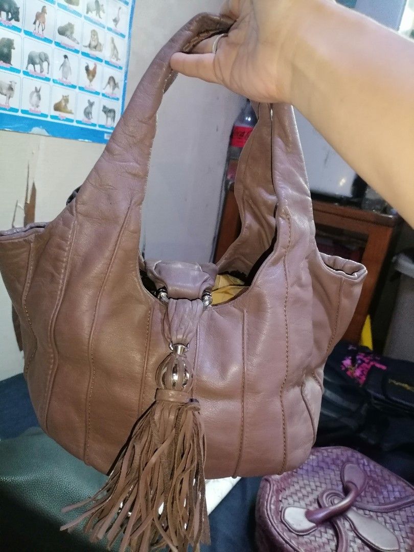 Lancel Leather Shoulder Bag with Tassel (Category: Shoulder Bags) located in Digos. Submitted by crodualady82694 (Listing ID 1470158656, Image 2). Description: - Brand: Lancel - Color: Dusty mauve / taupe - Material: Soft, slouchy genuine leather with vertical panel stitching - Accents: Large matching leather tassel and exterior embossed logo tab - Straps: Dual comfortable shoulder straps - Interior: Clean lining with a spacious everyday fit.
