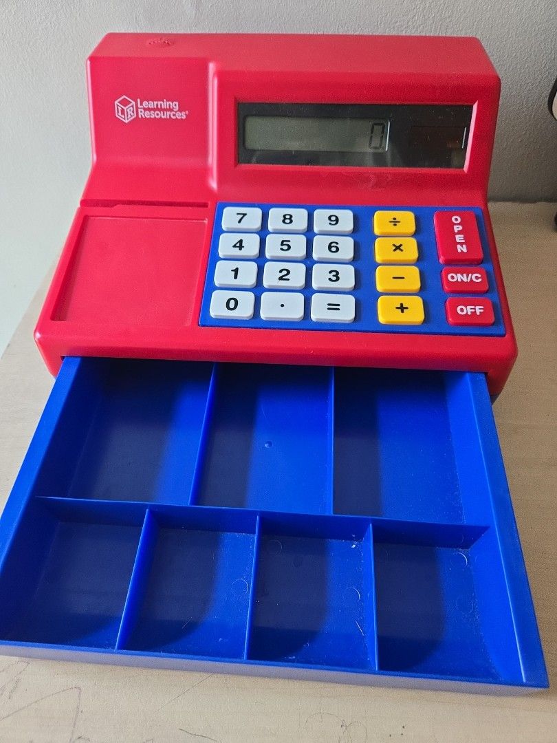 Learning Resources Pretend Play Cash Register (Category: Educational & Learning Toys) located in Pasig City. Submitted by izzy0202 (Listing ID 1470145985, Image 3). Description: - Brand: Learning Resources - Color: Red and blue - Working calculator display with operational buttons (OPEN, ON/C, OFF) - Pull-out cash drawer with compartments for coins and bills - Great for kids' math practice and store roleplay - Clean and ready for use.