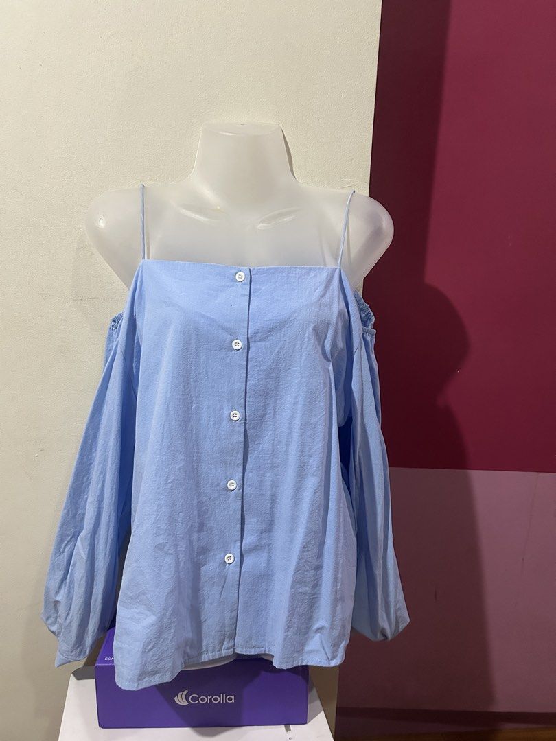 Light Blue Cold Shoulder Button Down Blouse (Category: Blouses) located in Marilao. Submitted by bamito (Listing ID 1470166880, Image 2). Description: - Color: Light blue - Design: Cold shoulder with spaghetti straps and square neckline - Details: Front button closure with white buttons - Fit: Relaxed fit through the body - Lightly Used.