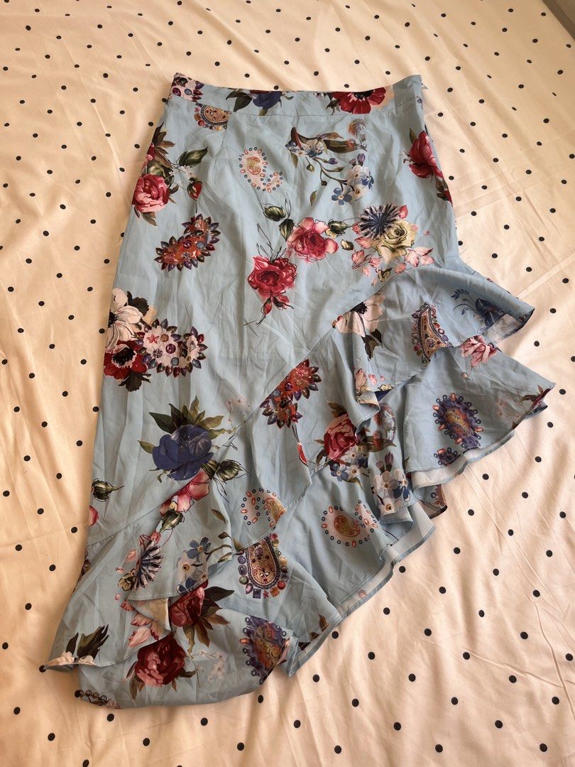 Light Blue Floral Ruffle Asymmetrical Skirt (Category: Skirts) located in Manila. Submitted by chimcheese (Listing ID 1470152122, Image 1). Description: - Style: Light blue midi skirt with colourful floral and paisley prints - Design: High-low hemline with cascading layered ruffles - Fit: Fitted waistband with a convenient side zipper closure - Material: Lightweight, breathable fabric ideal for warm weather - Perfect for: Casual day outs, brunch 