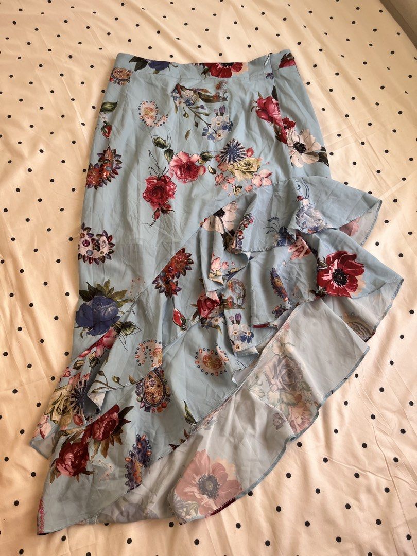 Light Blue Floral Ruffle Asymmetrical Skirt (Category: Skirts) located in Manila. Submitted by chimcheese (Listing ID 1470152122, Image 3). Description: - Style: Light blue midi skirt with colourful floral and paisley prints - Design: High-low hemline with cascading layered ruffles - Fit: Fitted waistband with a convenient side zipper closure - Material: Lightweight, breathable fabric ideal for warm weather - Perfect for: Casual day outs, brunch 