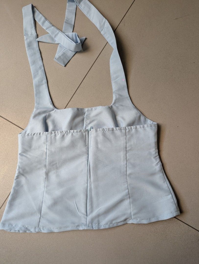 Light Blue Halter Neck Crop Top with Back Zip (Category: Sleeveless) located in Paranaque City. Submitted by clothingarchives (Listing ID 1470161649, Image 2). Description: - Color: Light blue pastel shade - Design: Halter neck with square neckline and adjustable button/tie straps - Fit: Fitted bodice with flattering vertical panel seams - Closure: Hidden back zipper - Style: Simple, chic summer essential - Condition: Excellent / Brand new.