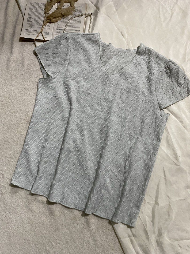 Light blue textured short sleeve v-neck top Small-Medium 36 (Category: Blouses) located in Poro. Submitted by joyceyuu (Listing ID 1470184367, Image 2). Description: - Color: Light blue - Neckline: V-neck - Details: Subtle diamond pattern texture, cap sleeves with gentle pleats - Fit: Casual, lightweight, and easy to pair with jeans or skirts - Condition: Clean and ready to wear.