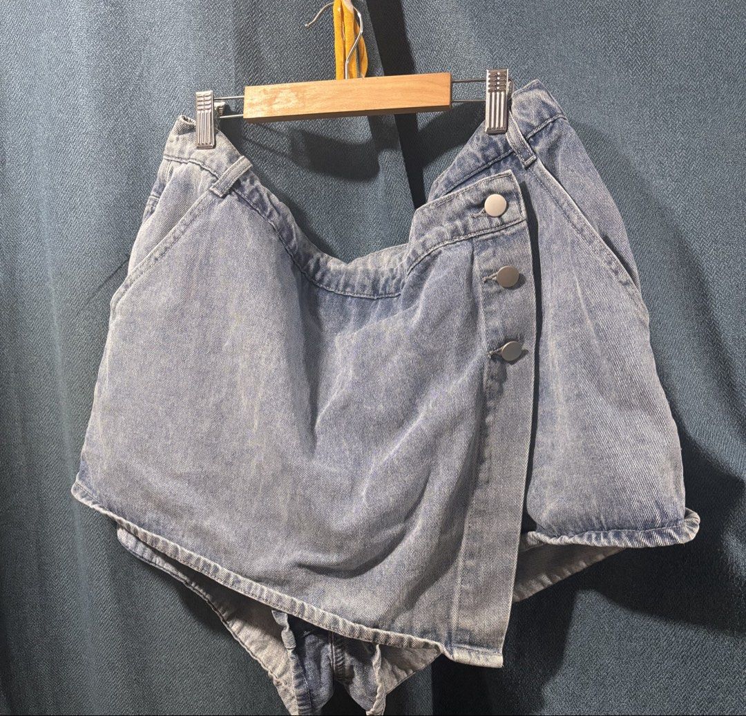 Light wash denim skort with button details (Category: Skirts) located in Cainta. Submitted by monica.bing (Listing ID 1470188566, Image 1). Description: - Style: High-waisted denim skort with asymmetrical front overlay panel - Details: Three metallic snap buttons on the side flap, front pockets - Color/Wash: Light wash denim - Condition: never used - Versatility: Perfect casual piece that pairs easily with basic tees and tanks size: 4XL but runs 