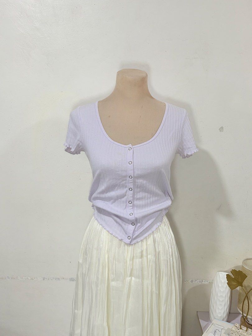 Lilac Ribbed Button-Down Short Sleeve Crop Top (Category: Shirts) located in Manila. Submitted by biacakes (Listing ID 1470262588, Image 2). Description: - Color: Lilac - Size: Fits Small to Medium - Material: Comfortable ribbed knit fabric - Details: Scoop neckline, full front snap button-down design, lettuce hem on sleeves - Hemline: Trendy asymmetrical pointed hem - Styling: Great for pairing with high-waisted skirts or pants - Condition: Bran