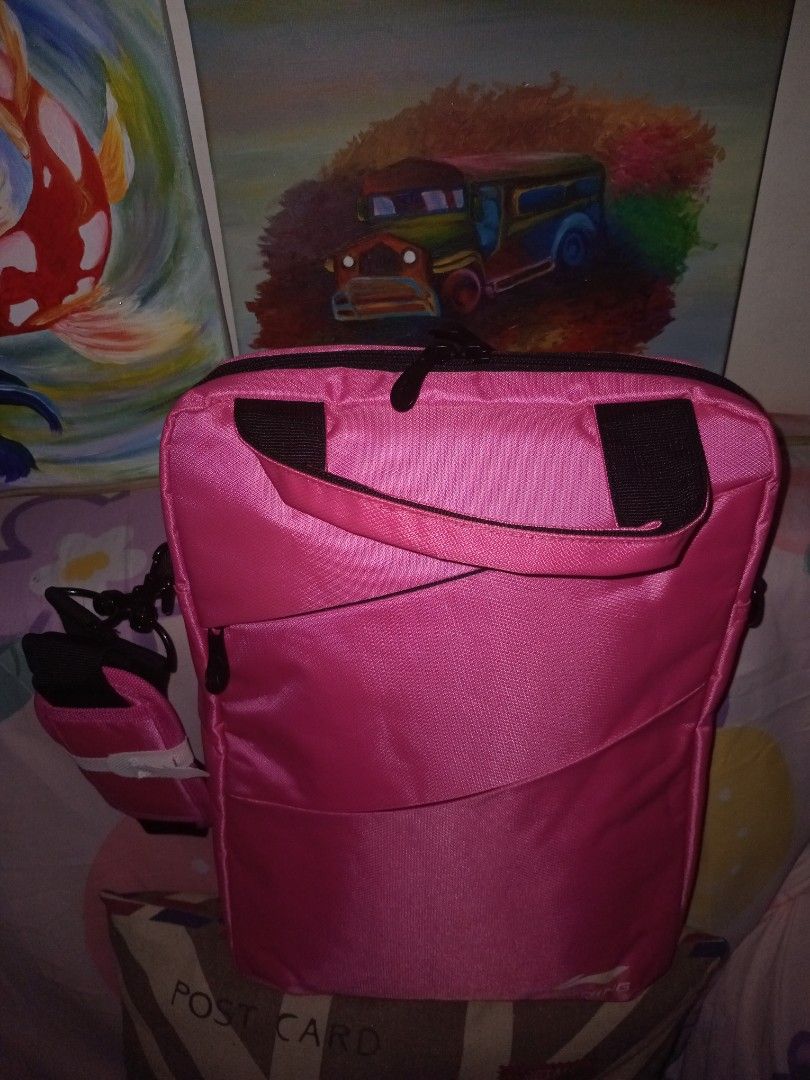 Li-Ning Pink Laptop Bag with Shoulder Strap (Category: Laptop Bags & Sleeves) located in Rodriguez. Submitted by maycol (Listing ID 1470224578, Image 2). Description: - Brand: Li-Ning - Color: Bright pink - Condition: Clean exterior, shoulder strap still wrapped in plastic - Storage: Zippered main compartment and front zipped pocket - Portability: Sturdy top carrying handles and a matching adjustable shoulder strap - Ideal use: Practical for dail