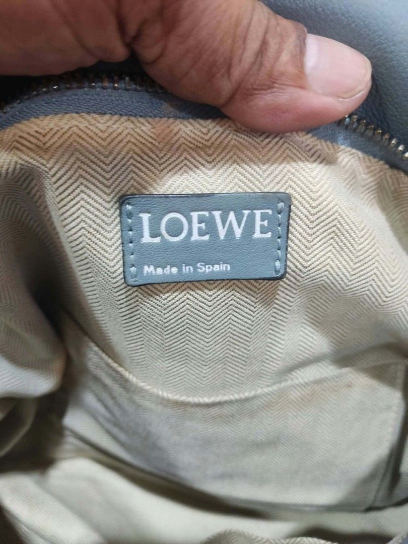 Loewe Hammock Light Blue Leather Shoulder Bag (Category: Luxury Bags & Wallets) located in Bay. Submitted by silverhorse-59c851 (Listing ID 1470269207, Image 3). Description: Light blue leather Loewe Hammock handbag. Structured shape with folded sides and top handles. Silver-tone hardware and top zip closure. Interior lined in beige chevron fabric with slip pockets. Debossed Loewe logo on the front corner. Includes interior leather brand tag and 
