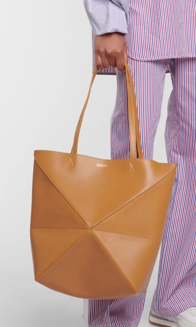Loewe Puzzle Fold Tote Tan Leather (Category: Tote Bags) located in Caloocan City. Submitted by mylove326 (Listing ID 1470267693, Image 3). Description: - Brand: Loewe - Material: Smooth calfskin leather in a versatile tan shade - Design: Structured geometric panel with unique folded construction - Details: Subtle gold embossed logo and contrast stitching near strap bases - Straps: Dual shoulder straps for comfortable daily wear - Closure: Open t
