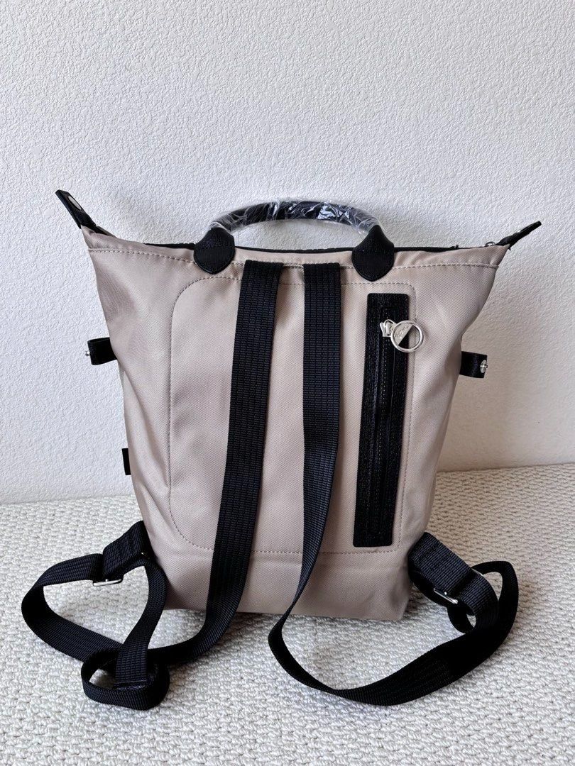 Longchamp Backpack (Category: Backpacks) located in Singapore. Submitted by sg_vela_professional_seller (Listing ID 1470204313, Image 7). Description: - Brand: Longchamp - Color: Neutral beige with black accents and hardware - Material: Lightweight, durable nylon fabric with sturdy straps - Features: Signature Longchamp branding, secure zippered outer pocket, and adjustable shoulder straps - Condition: Brand new and unused - Ideal for: Everyday c