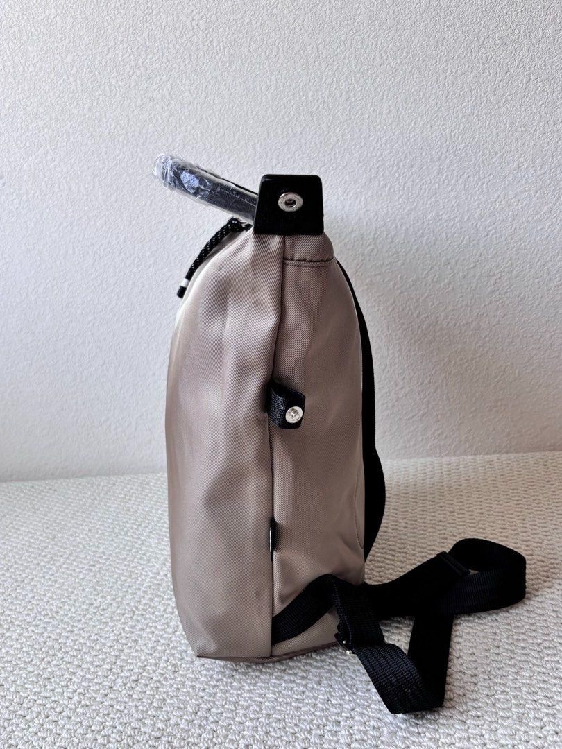 Longchamp Backpack (Category: Backpacks) located in Singapore. Submitted by sg_vela_professional_seller (Listing ID 1470204313, Image 5). Description: - Brand: Longchamp - Color: Neutral beige with black accents and hardware - Material: Lightweight, durable nylon fabric with sturdy straps - Features: Signature Longchamp branding, secure zippered outer pocket, and adjustable shoulder straps - Condition: Brand new and unused - Ideal for: Everyday c