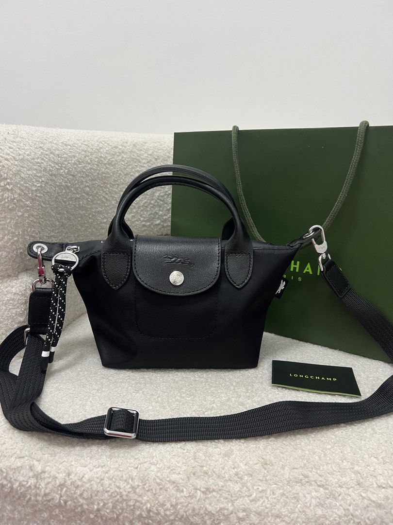 Longchamp Energy Crossbody Bag (Category: Cross-body Bags) located in Abulug. Submitted by jamiecammie (Listing ID 1470273338, Image 1). Description: - Material: Durable black nylon with sleek black leather flap and top handles - Hardware: Silver-tone accents with a secure snap button closure - Design: Features a stylish debossed horse logo on the flap - Versatility: Includes a removable, adjustable black shoulder strap with a trendy dotted rope 