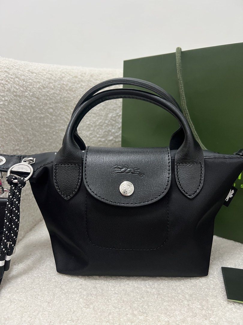 Longchamp Energy Crossbody Bag (Category: Cross-body Bags) located in Abulug. Submitted by jamiecammie (Listing ID 1470273338, Image 3). Description: - Material: Durable black nylon with sleek black leather flap and top handles - Hardware: Silver-tone accents with a secure snap button closure - Design: Features a stylish debossed horse logo on the flap - Versatility: Includes a removable, adjustable black shoulder strap with a trendy dotted rope 