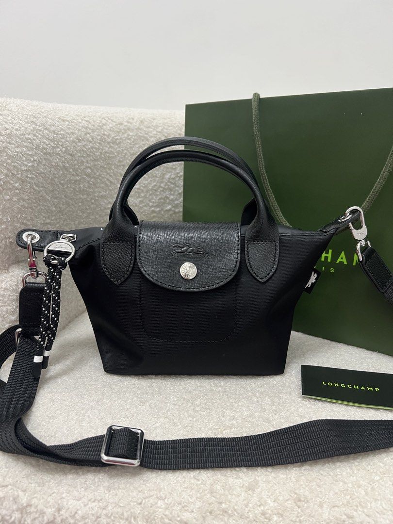 Longchamp Energy Crossbody Bag (Category: Cross-body Bags) located in Abulug. Submitted by jamiecammie (Listing ID 1470273338, Image 2). Description: - Material: Durable black nylon with sleek black leather flap and top handles - Hardware: Silver-tone accents with a secure snap button closure - Design: Features a stylish debossed horse logo on the flap - Versatility: Includes a removable, adjustable black shoulder strap with a trendy dotted rope 