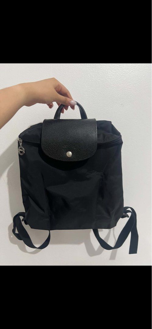 Longchamp Le Pliage Black Nylon Backpack (Category: Backpacks) located in Manila. Submitted by isabella_201013 (Listing ID 1470154687, Image 1). Description: - Authentic Longchamp backpack in versatile black - Durable nylon body with stylish dark leather flap and top handle - Signature silver zipper pull featuring the iconic rider logo - Comfortable, adjustable black fabric shoulder straps - Secure snap button closure on the front flap - Clean, m