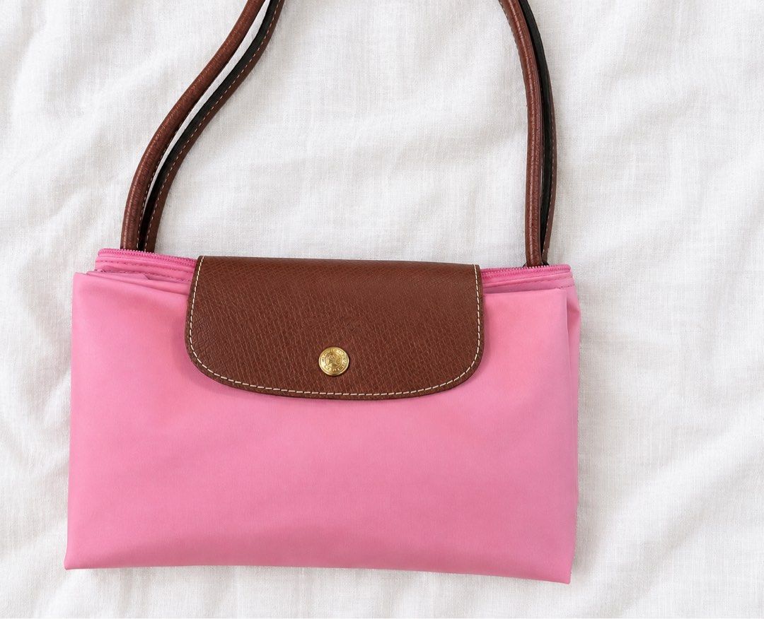 Longchamp Le Pliage Medium Long Handle (Category: Luxury Bags & Wallets) located in Santiago. Submitted by dobongsoon (Listing ID 1470319727, Image 1). Description: - Brand: Longchamp - Style: Nylon Tote Bag - Color: Bright pink with brown leather handles and flap - Hardware: Gold tone snap button closure - Interior: Clean off-white lining with a small slip pocket - Details: Double shoulder straps with contrast stitching - Authenticity: Inside ta