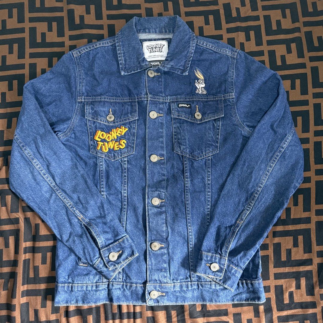 Looney Tunes Bugs Bunny Denim Jacket RRJ (Category: Coats, Jackets and Outerwear) located in Cainta. Submitted by amswardrobe (Listing ID 1470191090, Image 2). Description: - Brand: RRJ x Looney Tunes - Design: Medium wash blue denim jacket with large Bugs Bunny expression grid graphic on the back - Details: Embroidered Looney Tunes logo on the front pocket and small Bugs Bunny embroidery on the chest - Fit & Style: Classic collar, button-up clos