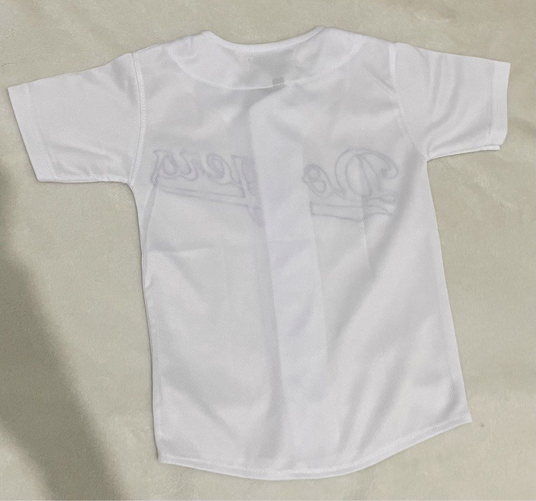 Los Angeles Dodgers White Baseball Jersey Size M (Category: Babies & Kids Fashion) located in Guiguinto. Submitted by beatan13 (Listing ID 1470320850, Image 2). Description: - Authentic Los Angeles Dodgers baseball jersey - Color: White with blue embroidered chest script - Style: Button-down front with short sleeves - Material: Lightweight, breathable athletic fabric - Size: Medium (tag at collar) - Condition: Great for streetwear, sports, and ca