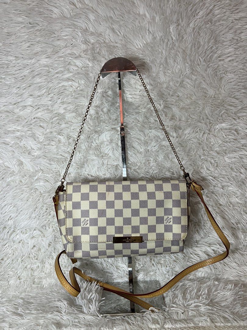 Louis Vuitton Damier Azur Canvas Shoulder Bag (Category: Luxury Bags & Wallets) located in San Carlos. Submitted by jessamaep_deer (Listing ID 1470271677, Image 1). Description: - Authentic Louis Vuitton shoulder bag - Iconic Damier Azur canvas in white and blue-grey - Elegant gold-tone hardware on the front flap and chain strap - Premium tan leather trim with an adjustable strap included - Fabric interior lining equipped with a convenient slip p