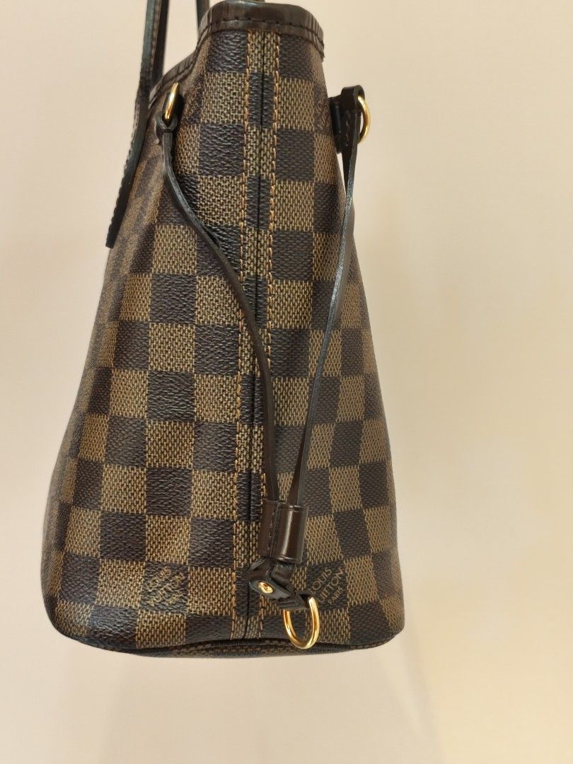 Louis Vuitton Damier Ebene Neverfull Tote Bag (Category: Luxury Bags & Wallets) located in Quezon City. Submitted by jastine20 (Listing ID 1470334490, Image 2). Description: - Authentic Louis Vuitton Damier Ebene canvas tote - Iconic brown checkerboard pattern with dark brown leather straps - Elegant gold-tone hardware details - Classic shoulder bag silhouette featuring adjustable side laces - Clean, structured design offering great everyday util