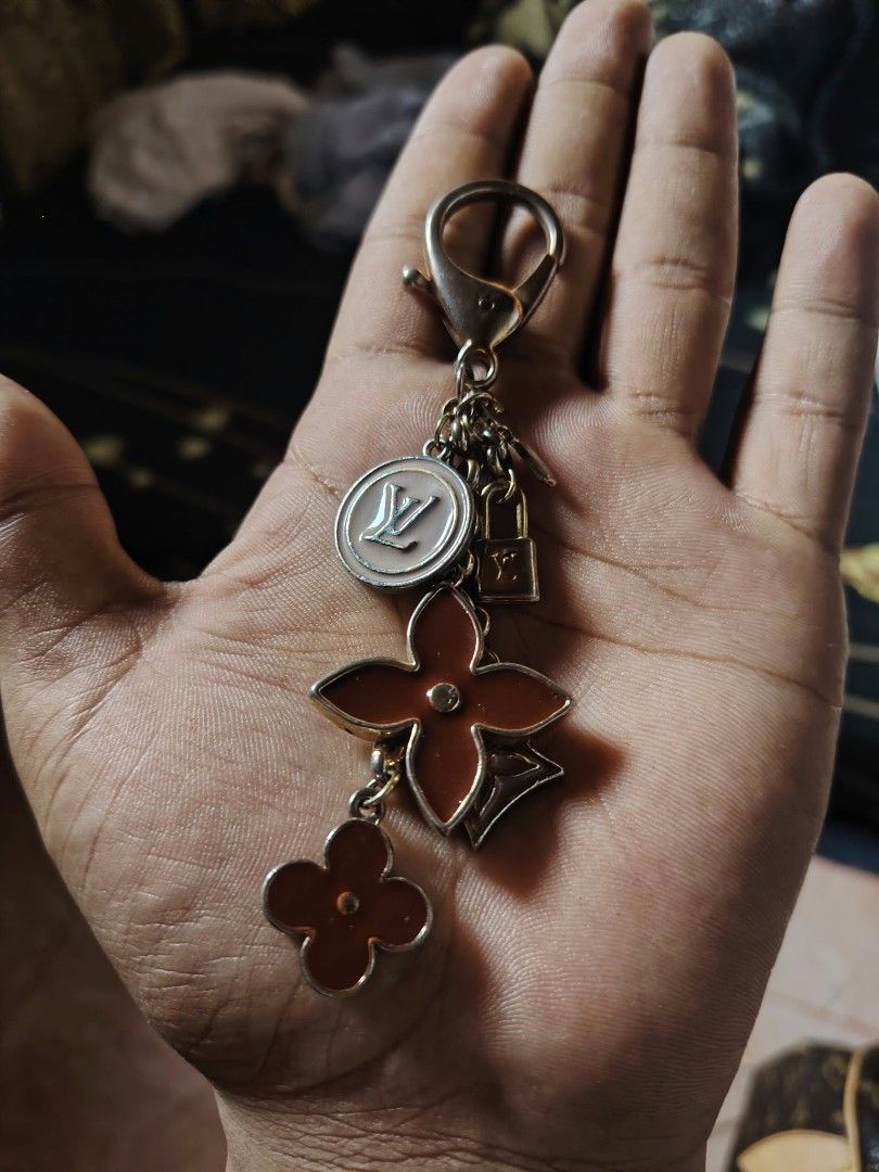Louis Vuitton Monogram Fleur Charm Keychain (Category: Luxury Accessories) located in Baguio. Submitted by tabuzomaria1422 (Listing ID 1470318639, Image 3). Description: - Authentic gold-tone Louis Vuitton keyring and bag charm - Features dangling LV circle logo, monogram flowers, tiny padlock, and key pendants - Detailed with engraved Louis Vuitton lettering on the clasp - Perfect for dressing up your favorite luxury bag or keeping keys secure -
