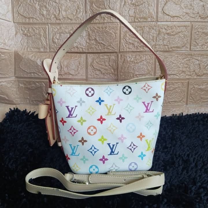 Louis Vuitton Multicolore Monogram Canvas Bucket Bag (Category: Luxury Bags & Wallets) located in Lubao. Submitted by dione_closet503 (Listing ID 1470219144, Image 1). Description: - Authentic Louis Vuitton Monogram Multicolore Bucket Bag in White - Iconic collaboration piece designed by Takashi Murakami - Crafted with vachetta leather trim and gold-tone hardware - Includes a short shoulder strap and an adjustable long strap - Classic collector's