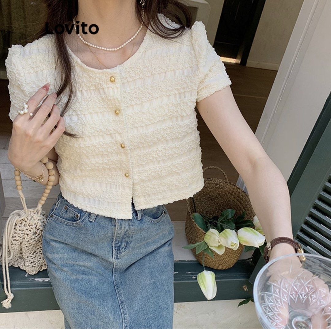 Lovito Button-Up Blouse (Category: Blouses) located in Makati City. Submitted by marymontalve (Listing ID 1470300364, Image 2). Description: - Brand: Lovito - Color: White - Style: Cropped short sleeve blouse - Details: All-over textured crinkle pattern, round neckline, gold-toned front buttons, and chic puff sleeves - Versatility: Great everyday piece, easy to match with high-waisted jeans or skirts orig price: 529.