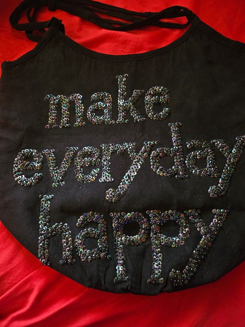 Make Everyday Happy Black Sequinned Tote Bag (Category: Tote Bags) located in Mandaluyong City. Submitted by ohwmaria (Listing ID 1470231041, Image 2). Description: - Brand/Designer: BY AISSATA MALHAIRE (pink interior tag with website) - Design: Black fabric tote with iridescent sequin lettering 'make everyday happy' - Features: Roomy interior with secure zip closure and double shoulder straps with strap detail - Style: Fun, casual everyday bag t