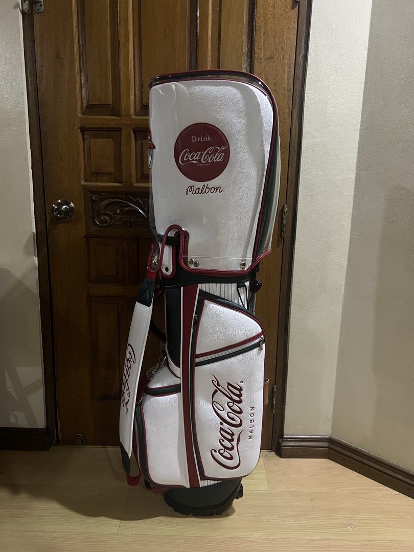 Malbon x Coca-Cola Golf Bag White Red (Category: Golf) located in Manila. Submitted by kensoncai8 (Listing ID 1470300558, Image 1). Description: - Limited Malbon Golf x Coca-Cola collaboration - Premium white synthetic leather with classic red branding and pinstripe details - Multiple zippered compartments for organized storage - Includes matching hood cover and comfortable padded shoulder strap - Excellent clean condition with protective plastic