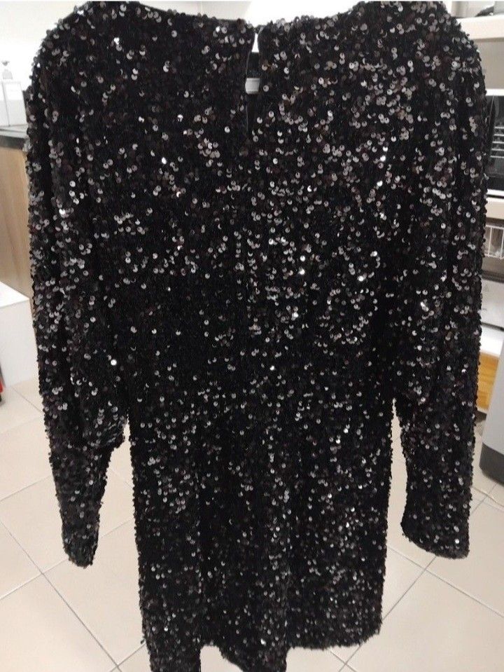 Mango Black Sequin Mini Dress (Category: Dresses) located in Makati City. Submitted by mkdmaniego (Listing ID 1470225623, Image 2). Description: - Brand: Mango - Style: Black sequin mini dress with long sleeves and boat neckline - Details: Fully covered in sparkly black sequins, button closure at the back neck - Condition: Worn once, great shape with zero missing sequins - Fit: True to size, perfect for parties and night outs Fabric with sequin. 