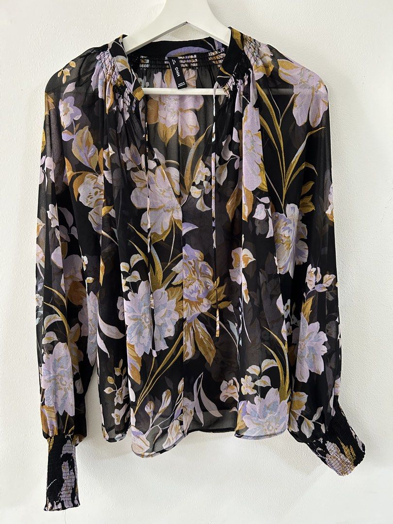 Mango Mango Black Floral Chiffon Blouse Size S (Category: Blouses) located in Manila. Submitted by isabelle_1104 (Listing ID 1470275732, Image 2). Description: - Brand: Mango - Design: Black with purple, lilac, and mustard yellow floral pattern - Neckline: V-neck with tie strings and shirring detail - Sleeves: Long balloon sleeves with smocked cuffs - Fabric: Sheer, lightweight material - Origin: Made in Morocco - Condition: Excellent pre-loved /