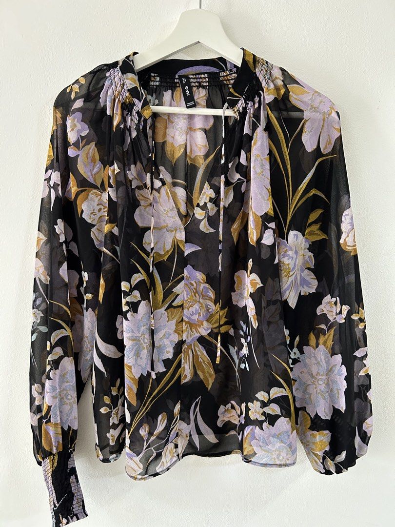 Mango Mango Black Floral Chiffon Blouse Size S (Category: Blouses) located in Manila. Submitted by isabelle_1104 (Listing ID 1470275732, Image 1). Description: - Brand: Mango - Design: Black with purple, lilac, and mustard yellow floral pattern - Neckline: V-neck with tie strings and shirring detail - Sleeves: Long balloon sleeves with smocked cuffs - Fabric: Sheer, lightweight material - Origin: Made in Morocco - Condition: Excellent pre-loved /