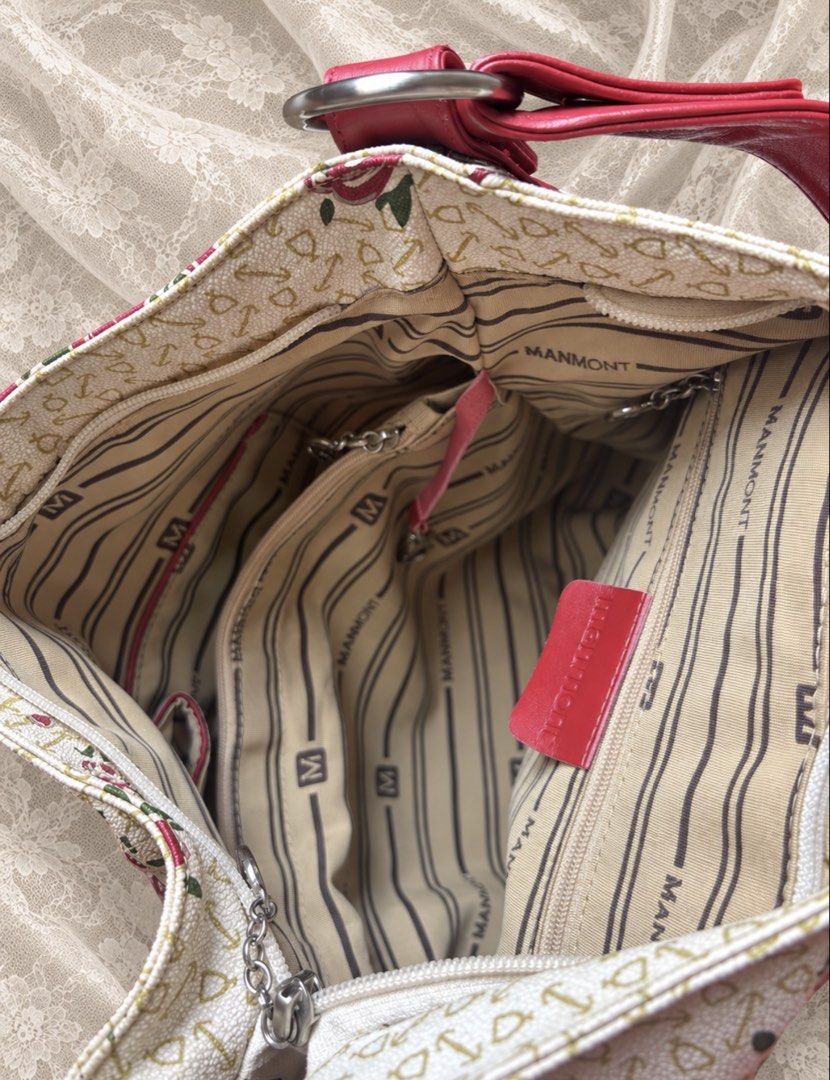 Manmont floral shoulder bag with red straps (Category: Shoulder Bags) located in Manila. Submitted by calliope777 (Listing ID 1470213521, Image 3). Description: - Elegant cream handbag with a red rose print and cute key/heart motifs - Vibrant red faux leather shoulder straps with stylish metal rings - Striped fabric interior featuring authentic Manmont branding - Multiple interior compartments and zipped pockets to keep your items organized - Con