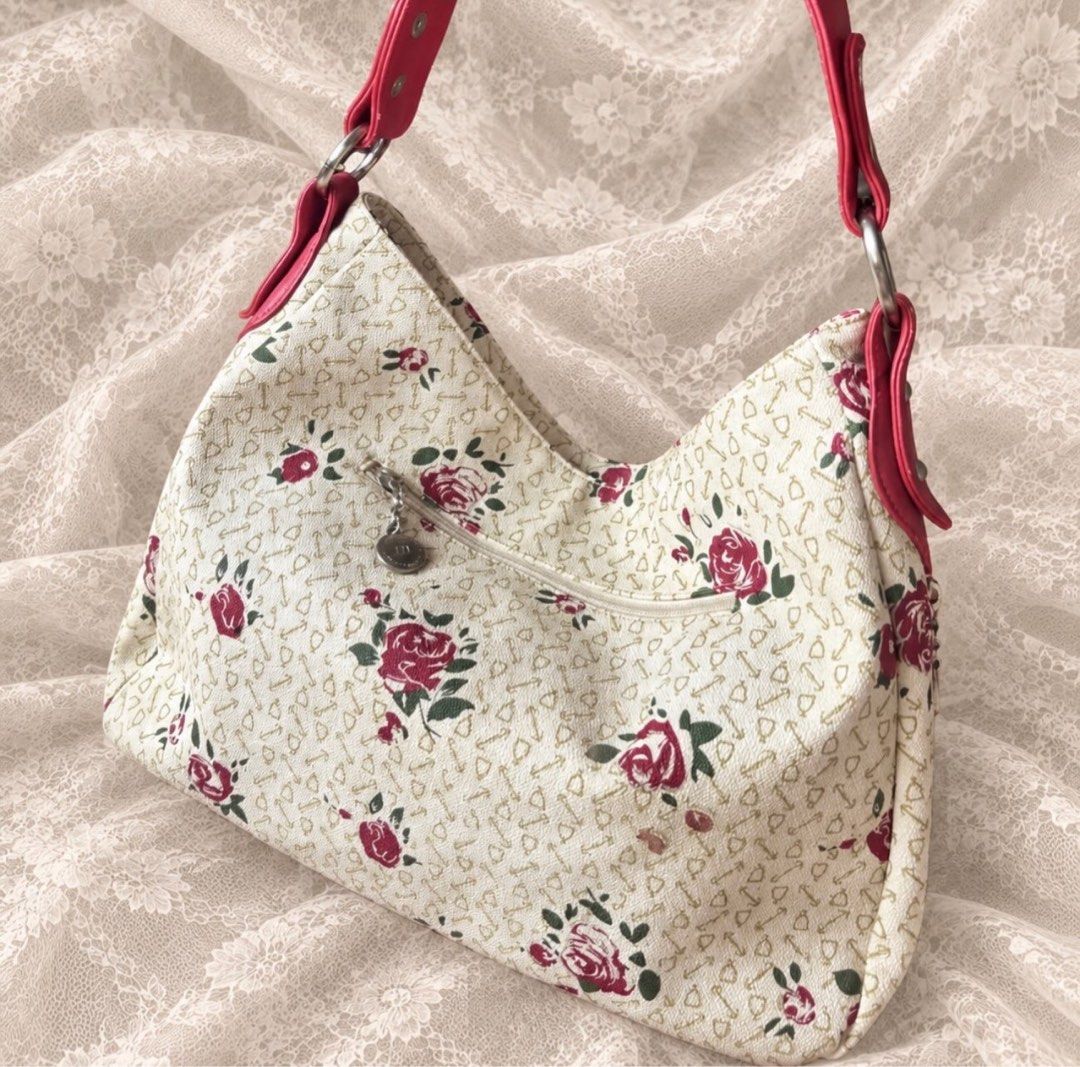 Manmont floral shoulder bag with red straps (Category: Shoulder Bags) located in Manila. Submitted by calliope777 (Listing ID 1470213521, Image 2). Description: - Elegant cream handbag with a red rose print and cute key/heart motifs - Vibrant red faux leather shoulder straps with stylish metal rings - Striped fabric interior featuring authentic Manmont branding - Multiple interior compartments and zipped pockets to keep your items organized - Con