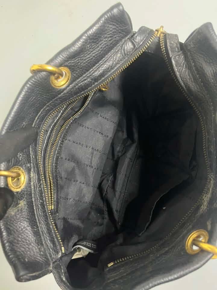 Marc by Marc Jacobs Classic Q (Category: Luxury Bags & Wallets) located in Manila. Submitted by royalpengwen (Listing ID 1470307814, Image 2). Description: - Brand: Marc by Marc Jacobs - Material: Genuine black leather with gold-tone hardware - Closure: Secure zip-top closure - Handles: Structured top handles with metallic details - Interior: Fabric lining with logo pattern, one zip pocket, and slip pockets - Origin: Made in Indonesia - Condition