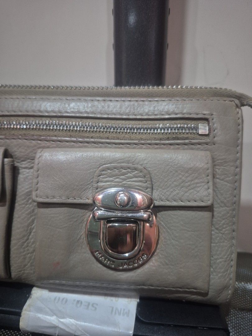 Marc Jacobs Grey Leather Wallet with Front Pocket (Category: Wallets & Card holders) located in Iloilo. Submitted by gorgeoustatz (Listing ID 1470307180, Image 2). Description: - Authentic Marc Jacobs leather wallet in a versatile neutral grey shade - Secure front flap pocket with distinctive turn-lock hardware - Handy vertical zippered compartment for extra storage - Premium supple textured leather with sleek silver-tone accents - Smooth-running
