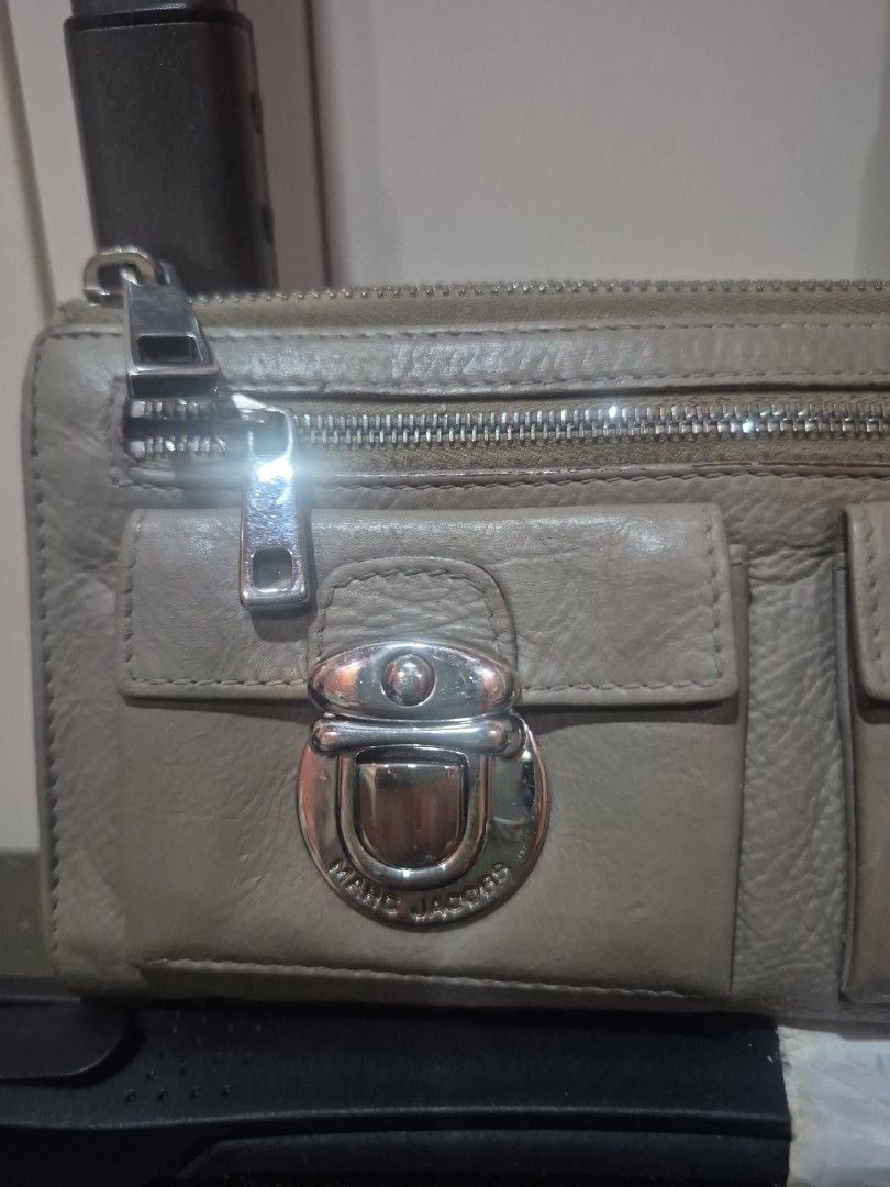 Marc Jacobs Grey Leather Wallet with Front Pocket (Category: Wallets & Card holders) located in Iloilo. Submitted by gorgeoustatz (Listing ID 1470307180, Image 3). Description: - Authentic Marc Jacobs leather wallet in a versatile neutral grey shade - Secure front flap pocket with distinctive turn-lock hardware - Handy vertical zippered compartment for extra storage - Premium supple textured leather with sleek silver-tone accents - Smooth-running
