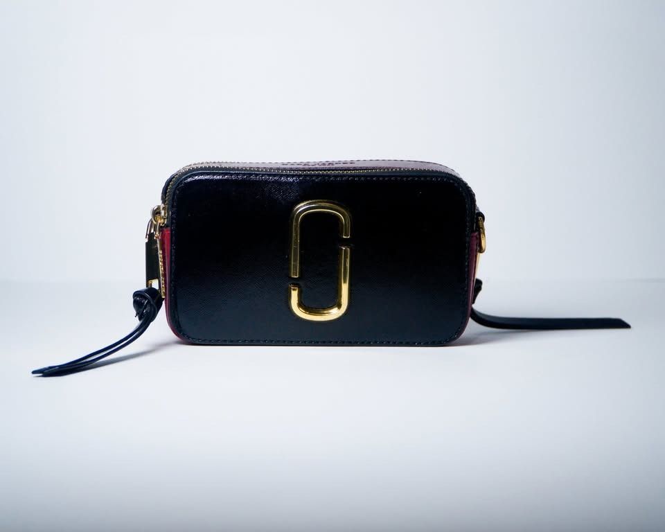 Marc Jacobs Snapshot Black Red Burgundy (Category: Cross-body Bags) located in Caloocan City. Submitted by jnlchvz0612 (Listing ID 1468994554, Image 2). Description: - Authentic Marc Jacobs Snapshot bag - Colorway: Black, red, and burgundy - Hardware: Iconic gold-tone double J logo - Compartments: Double zip design with leather pull tabs - Style: Compact crossbody for everyday use - Inclusions: Bag only.