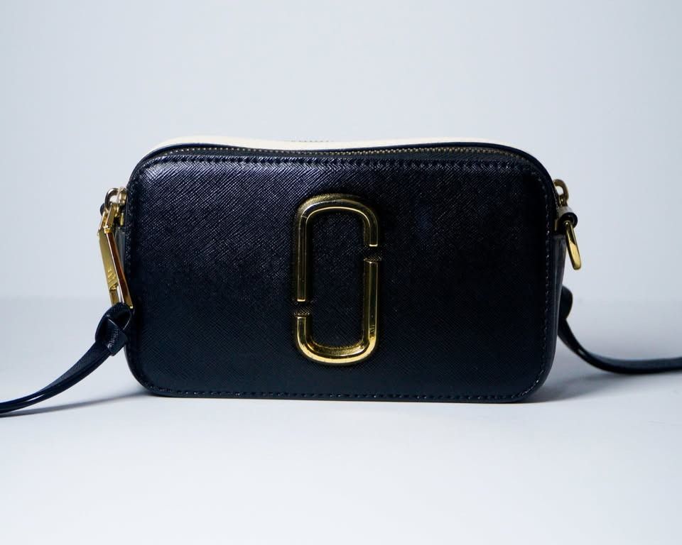 Marc Jacobs Snapshot Black White (Category: Cross-body Bags) located in Taguig. Submitted by jnlchvz0612 (Listing ID 1470188867, Image 1). Description: - Authentic Marc Jacobs camera bag in classic black and white leather - Eye-catching gold-tone Double J logo hardware on the front - Secure top zip closure for your daily essentials - Includes a matching black adjustable strap with gold metal clasps - Compact size, perfect for casual days or night