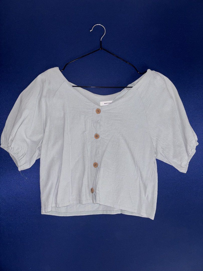 Matinée Light Green Button-Front Crop Top (Category: Sleeveless) located in Manila. Submitted by atinuuuh (Listing ID 1470205951, Image 1). Description: - Brand: Matinée - Color: Light blue - Style: Crop top with relaxed fit - Details: Short puff sleeves with elastic cuffs, V-neckline, 4 brown wooden buttons - Fabric: Lightweight and breathable - Condition: Great for casual everyday wear.