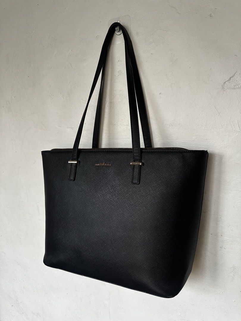 Matthews Black Leather Tote Bag (Category: Tote Bags) located in Manila. Submitted by omelette.12 (Listing ID 1470246821, Image 3). Description: - 1,799 original price, rfs: not using it anymore - Material: Premium Saffiano leather texture with chic gold lettering logo - Closure & Straps: Secure top zip closure with comfortable dual shoulder straps - Interior: Spacious compartment for all your daily essentials, laptop, or school items - Design: C